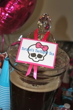 there is a drink in a glass with a pink bow around it and a name tag on the top