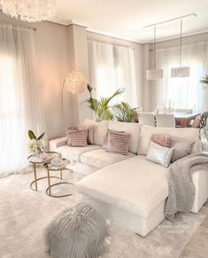 a living room filled with white furniture and lots of pillows on top of it's couches