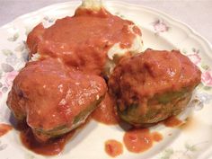 two stuffed meatballs covered in sauce on a plate