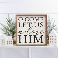 a wooden sign that says o come let us adore him on top of a shelf