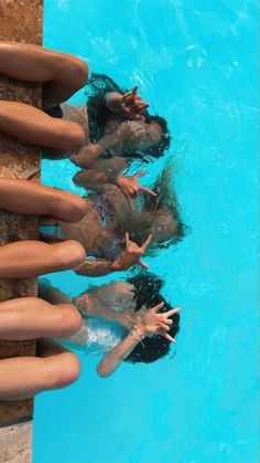 three people are swimming in a pool with their hands on the side of the pool