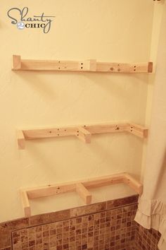 a bathroom with two wooden shelves on the wall