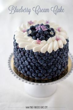 a blueberry cream cake with white frosting and purple flowers