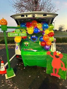 the sesame street car is decorated with balloons and decorations for halloween time, as well as an elm street sign