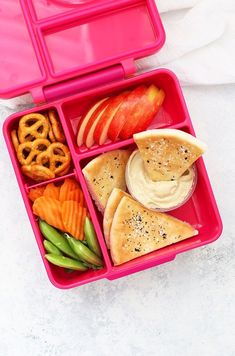 a pink lunch box filled with fruit, pretzels and crackers in it