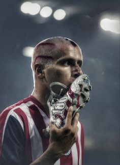 a soccer player with his face painted red, white and blue holding a ball in one hand