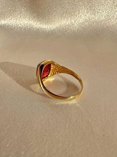 Antique 18k yellow gold ring from the United Kingdom. This signet ring features a vibrant synthetic ruby cabochon. Great antique condition Size: 7.5 resizable* Weight: 3.5 grams Band: 11.1 mm (front), 1.7 mm (back) Synth Ruby: 8.3 mm x 10.0 mm Hallmarks:18CT 18k Yellow Gold Ring, Yellow Gold Ring, Signet Ring, Yellow Gold Rings, Gold Ring, United Kingdom, Gold Rings, Ruby, Yellow Gold