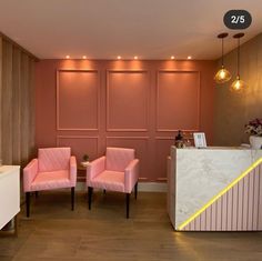 two pink chairs sitting in front of a counter