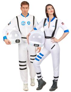 man and woman in white space suits posing for the camera with helmets on their hands