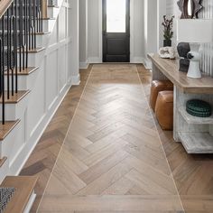 an entryway with wood floors and white walls, along with a wooden bench in the center