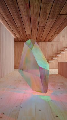 an abstract sculpture is shown in the middle of a room with wooden floors and walls