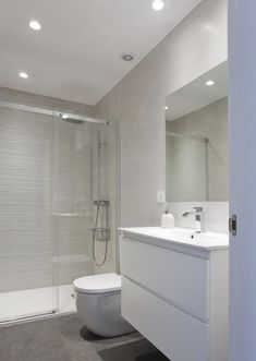 a bathroom with a toilet, sink and shower in it's stall area next to a walk - in shower