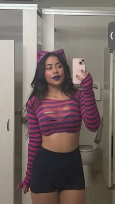 a woman taking a selfie in a bathroom wearing a cat costume and holding a cell phone