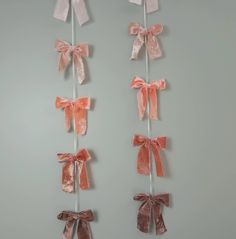 three pink bows are hanging on the wall