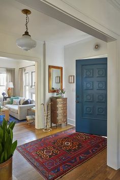 a living room with a blue door and rug on the floor