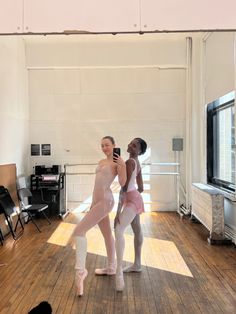 two ballerinas are standing in an empty room