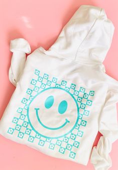 Woman & Girl Sweater | Girls Sweatshirt | Adult Sweater | Mama Sweatshirt | Smiley Face Sweater  Gildan Unisex Adult/Youth Heavy Cotton Long Sleeve Sweatshirt, it has a design in Black HTV (Heat Transfer Vinyl) Design: Front: Smiley face (pocket size) Back: Checkered Smiley face  Important: The dimensions of the designs will be proportional to the size of the Sweater. Available Sweatshirt colors:   - White    - Sport Grey     - Black   Details: The Gildan 18000 Adult Sweatshirt is made from a he White Long Sleeve Fun Sweatshirt, White Hooded Top With Screen Print, Playful White Long Sleeve Sweatshirt, Playful Cotton Hoodie With Graphic Print, Cute White Sweatshirt With Graphic Print, White Hoodie With Screen Print, White Screen Print Hoodie, Retro White Hoodie With Graphic Print, Fun White Sweatshirt For Winter