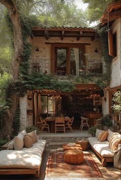 an outdoor living area with couches, tables and plants on the outside wall in front of it