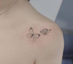 two butterflies on the back of a woman's shoulder