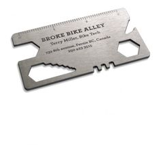 a metal bottle opener with a ruler on the front and back of it that says broke bike alley