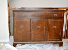 an old wooden cabinet is being worked on in the corner of a room with white walls