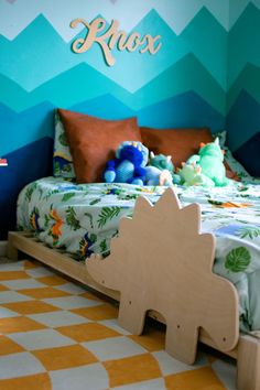 a child's bedroom decorated in blue, green and yellow with an elephant bed