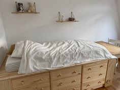 a bed with white sheets and pillows in a room