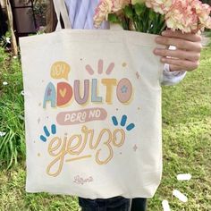 a person holding a tote bag with flowers in it that says, adulto perro no epero