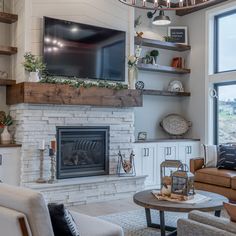 a living room filled with furniture and a flat screen tv mounted on the wall above a fire place