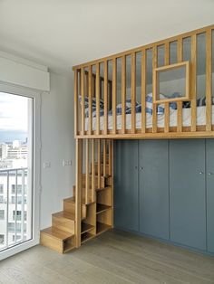 there is a bunk bed in the middle of this room with stairs leading up to it