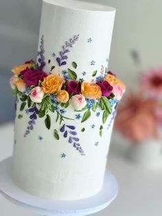 a white cake decorated with flowers and leaves