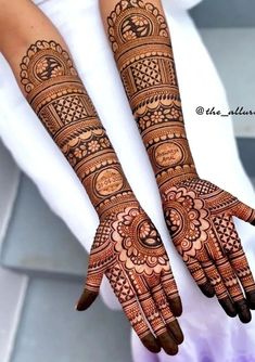 two hands with henna tattoos on them