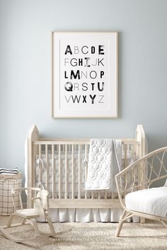 a baby's room with a white crib, rocking chair and alphabet poster