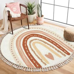 a round rug with an abstract design on the floor next to a chair and potted plant