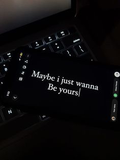 a keyboard with a message on it sitting next to a computer monitor that says maybe i just wanna be yours