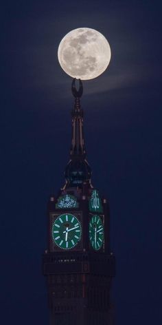 a clock tower with the moon in the background