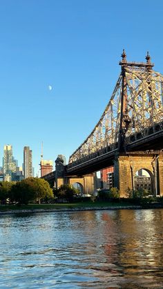 a bridge spanning the width of a large body of water in front of a city skyline