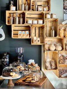 the shelves are filled with different types of breads and pastries in wooden boxes