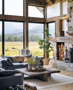 a living room filled with furniture and a fire place in front of a large window