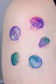 a woman's thigh with jellyfish tattoos on it