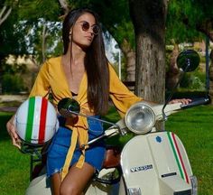 a woman sitting on top of a scooter with a ball in her hand