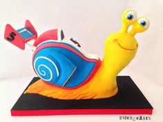 a cake shaped like a snail on top of a book