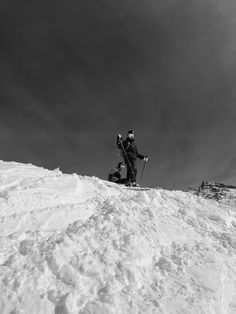 two people standing on top of a snow covered slope