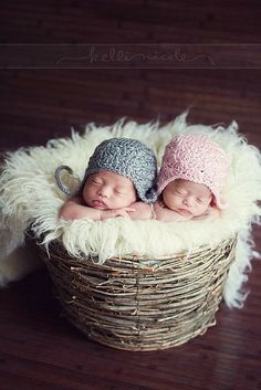 two newborn babies are sleeping in a basket