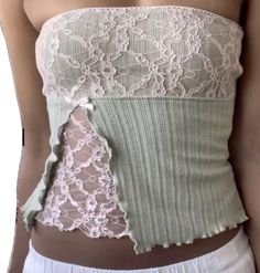 a woman wearing a green and white corset with lace on the bottom,