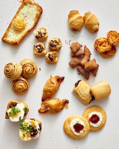 many different types of pastries on a white surface