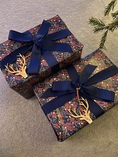 two wrapped presents with blue bows and deer antlers on them