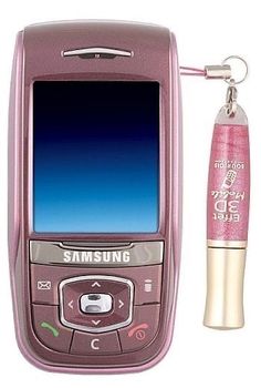 a pink cell phone next to a keychain with a purple pen on it