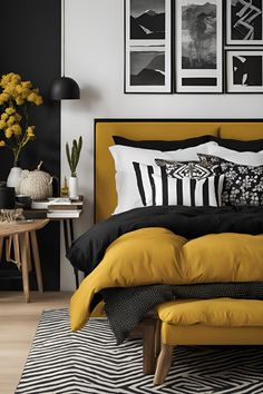 a bedroom with black and white decor, yellow bedding and pictures on the wall