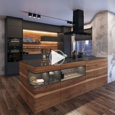 a modern kitchen with wooden floors and black counter tops, along with an island in the middle